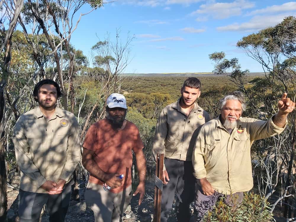 Four men including Eugene and Rocky Eades stand in the bush.